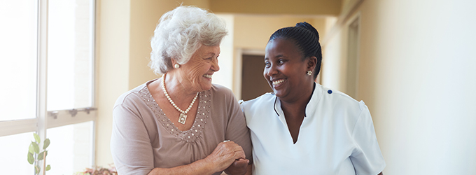 a nurse and an elderly lady walking down a hallway